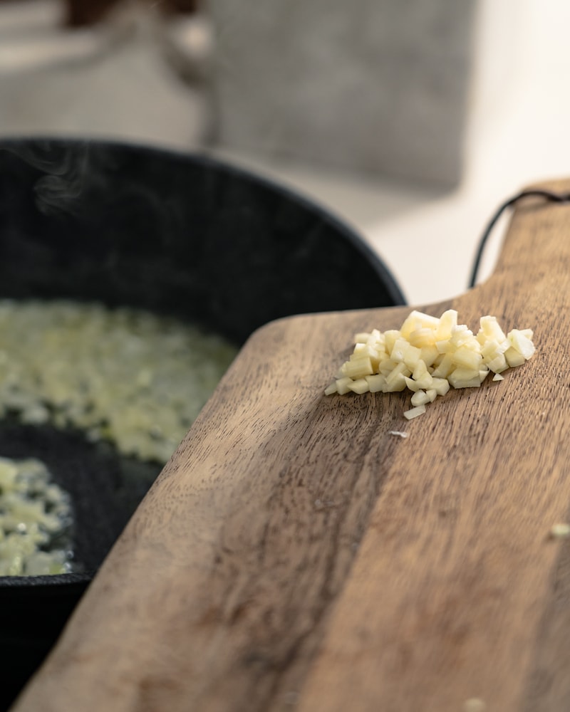 Auf diesem Bild siehst du wie Knoblauch dazugegeben wird.