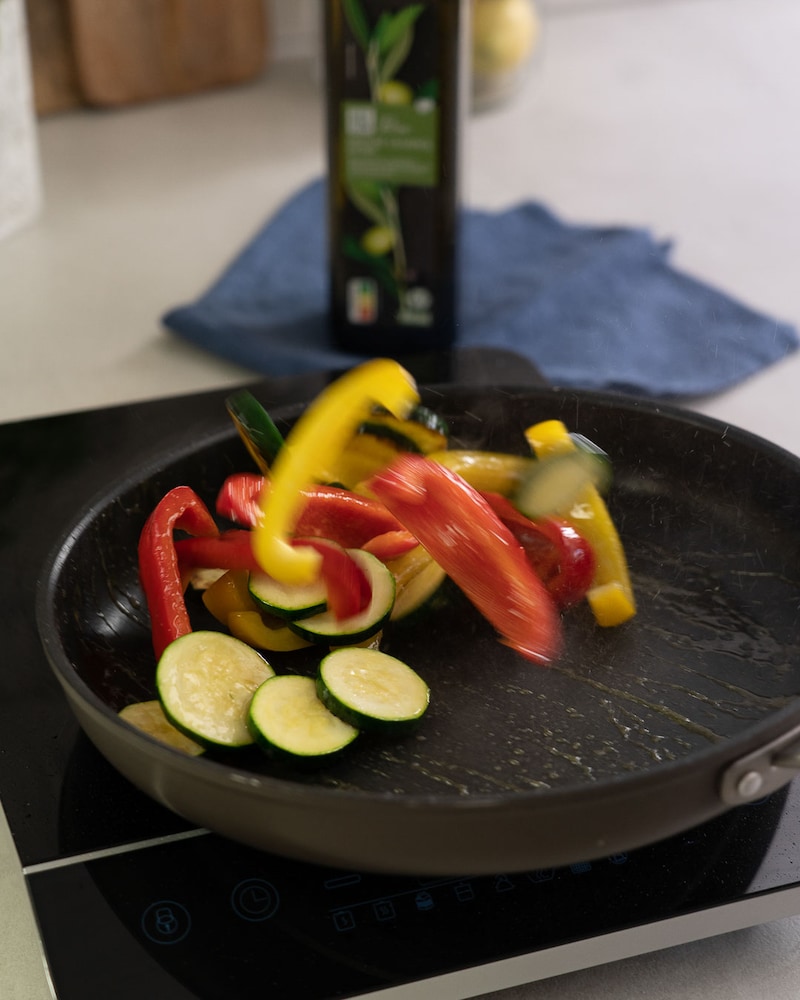 Dieses Bild zeigt wie Paprika und Zucchini gebraten werden.