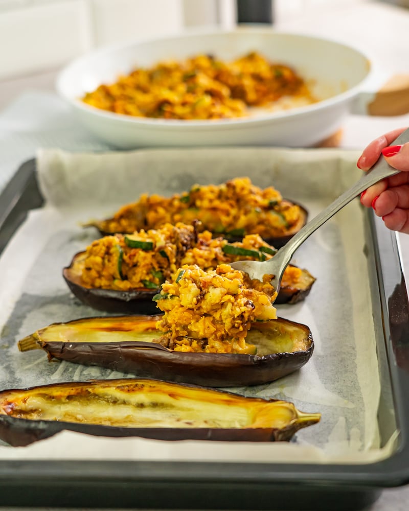 Dieses Bild zeigt wie die Zucchini aus dem Ofen genommen und gefüllt werden.