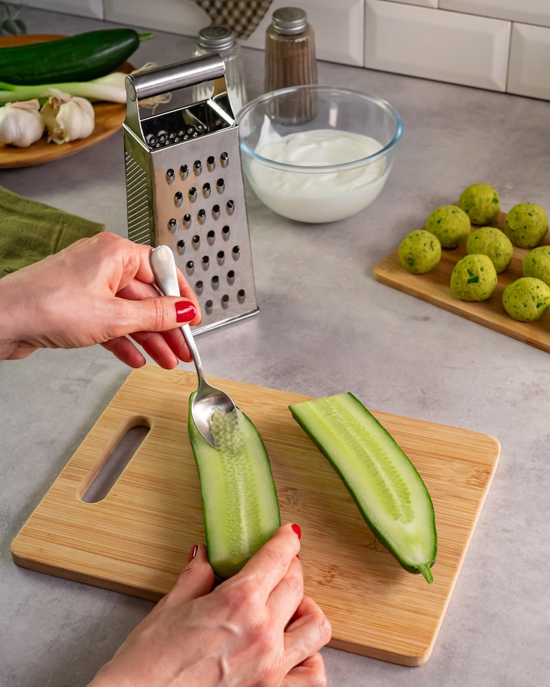 Auf diesem Bild siehst du wie eine Gurke entkernt wird.