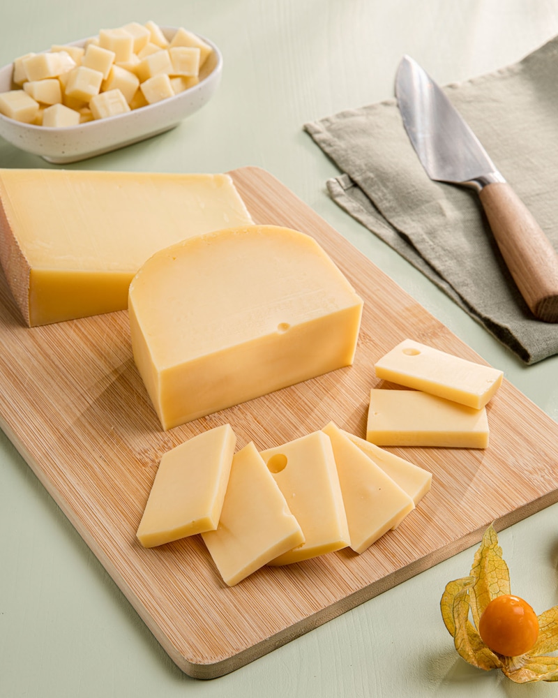 Dieses Bild zeigt wie der Käse geschnitten wird.
