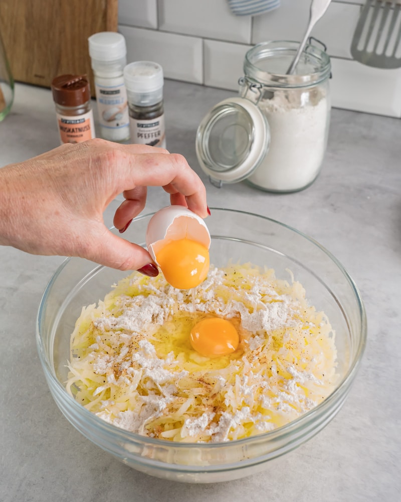 Diese Bild zeigt wie die Eier zu der Kartoffelmasse gegeben wird.
