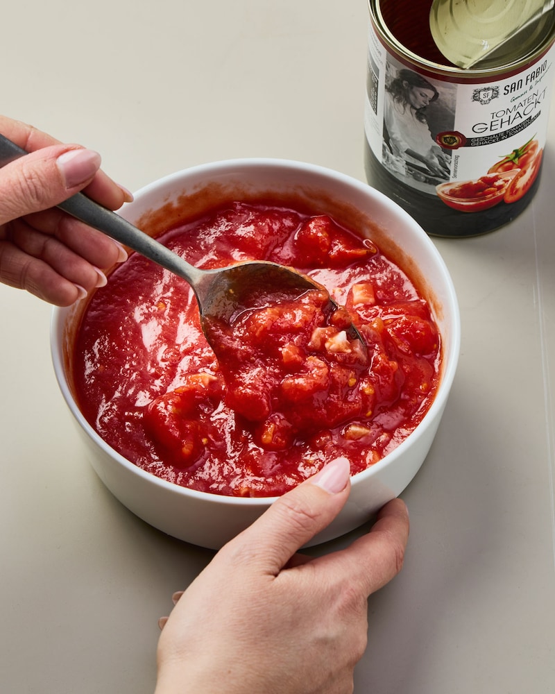 Dieses Bild zeigt wie die Tomatensoße verrührt wird.
