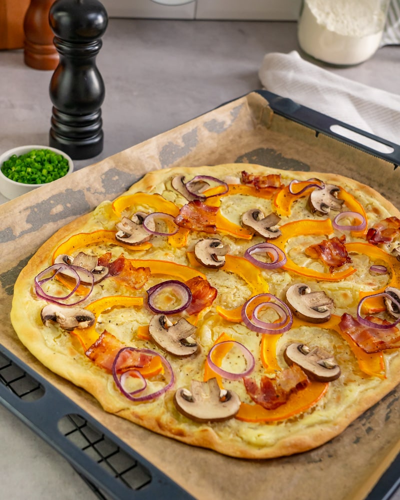 Dieses Bild zeigt den fertigen Kürbis Flammkuchen mit Speck.