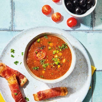 Sommerliche Gazpacho mit Schinkenstangen und schwarzen Oliven
