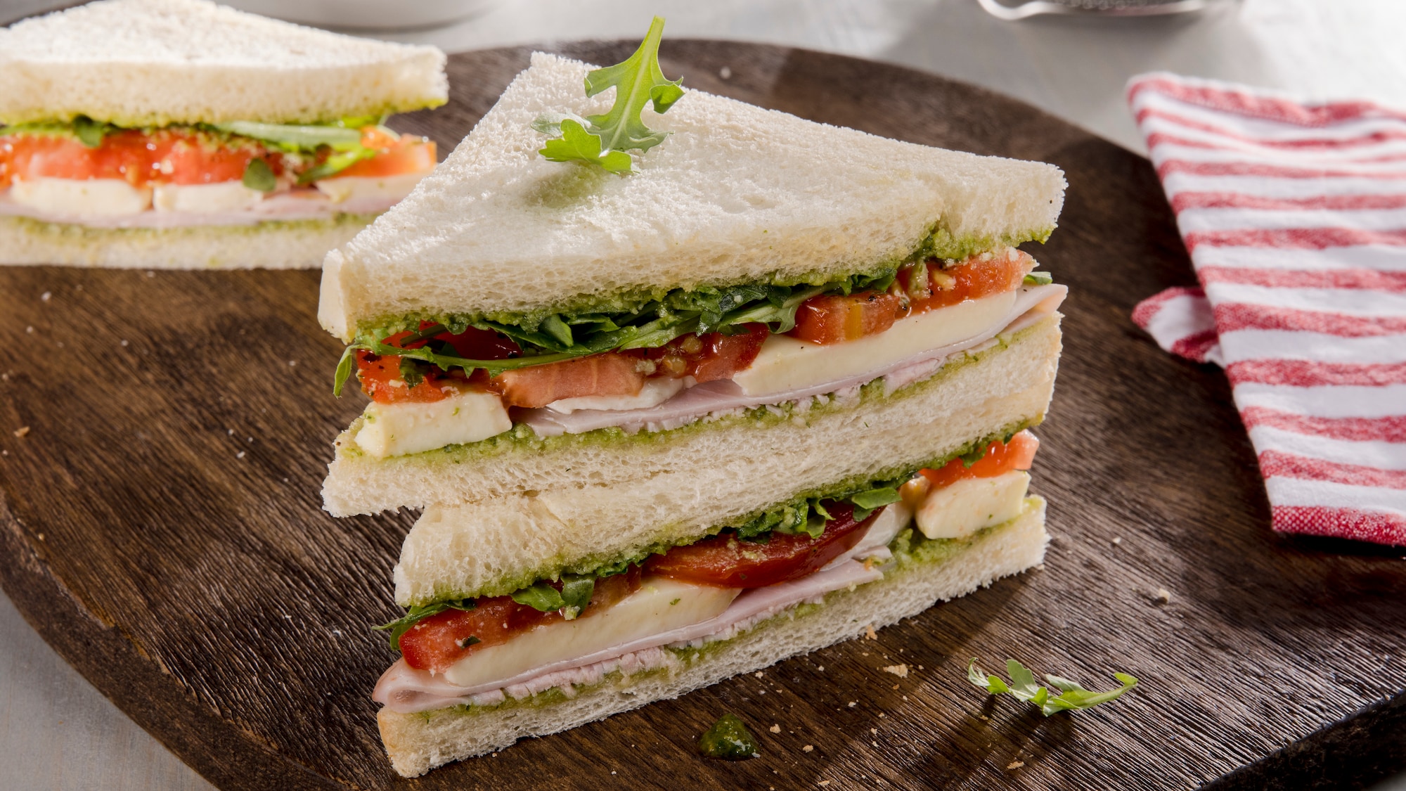 Aufgeschnittene Tramezzini auf einem Holzbrett