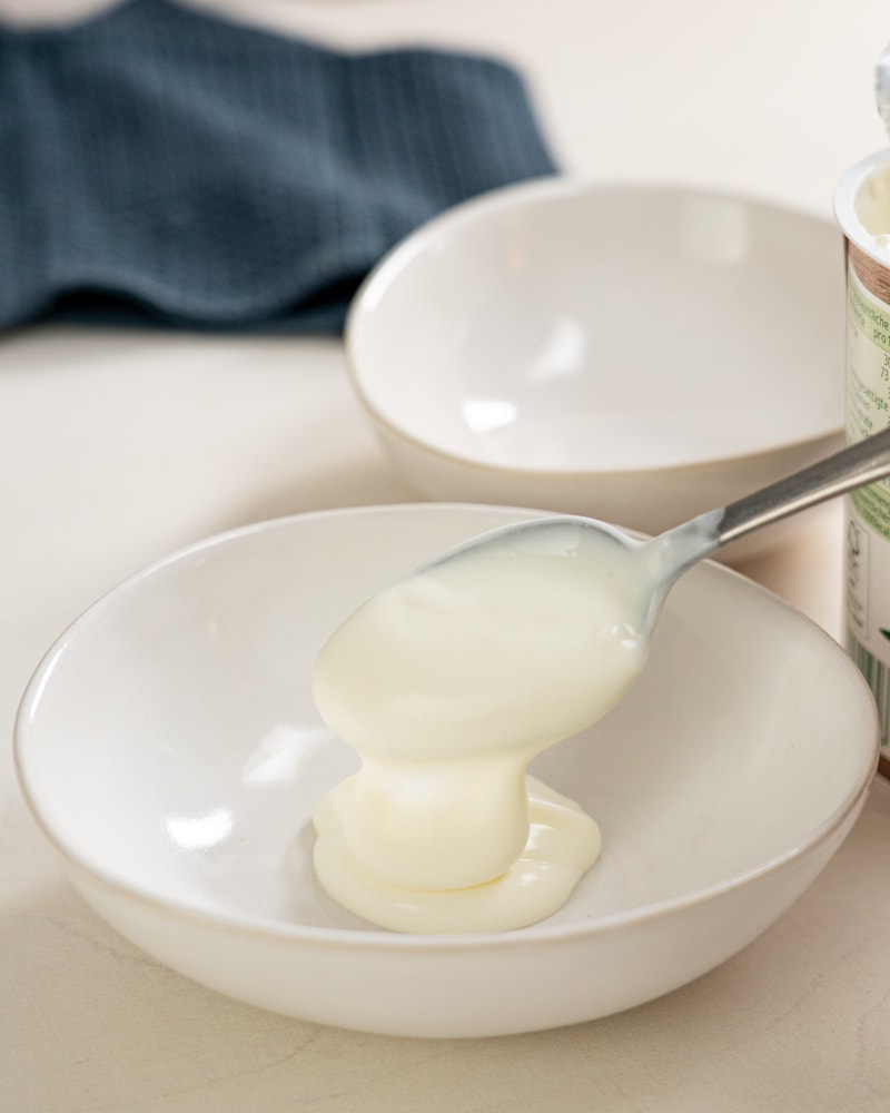 Auf diesem Bild siehst du wie Joghurt in eine Schüssel gegeben wird.