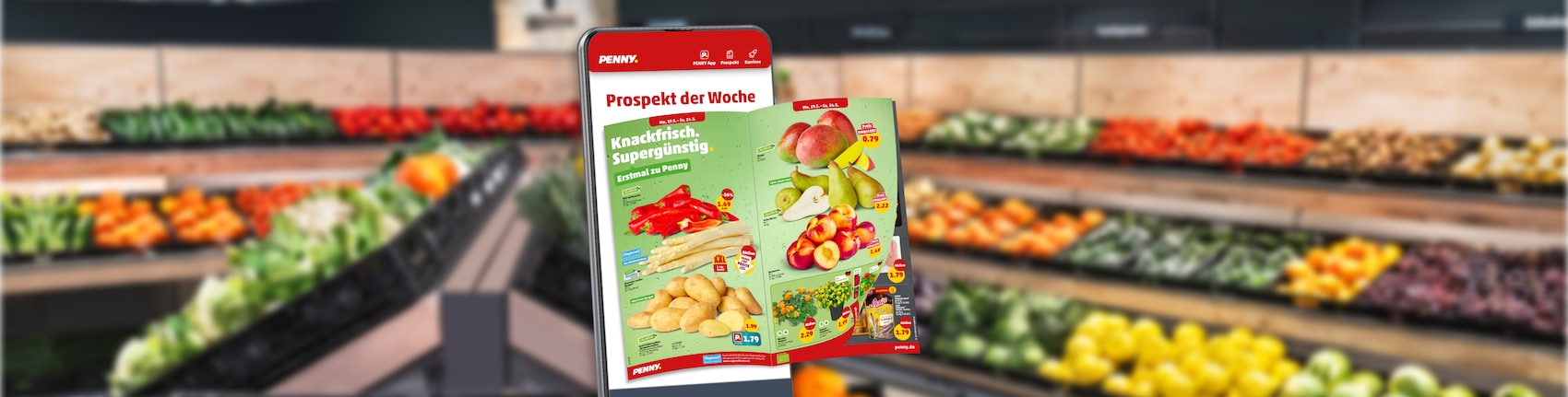 Ein Handy mit Blätterprospekt vor PENNY Marktregalen 