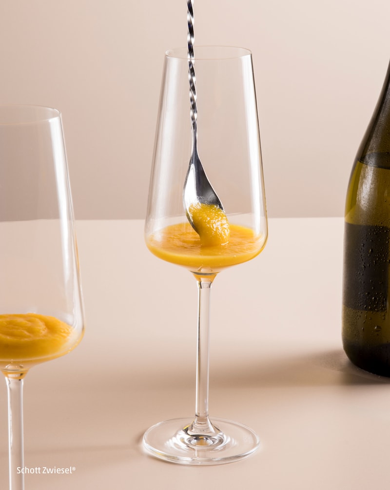 Dieses Bild zeigt ein Löffel in dem Glas wo der Bellini drin ist.