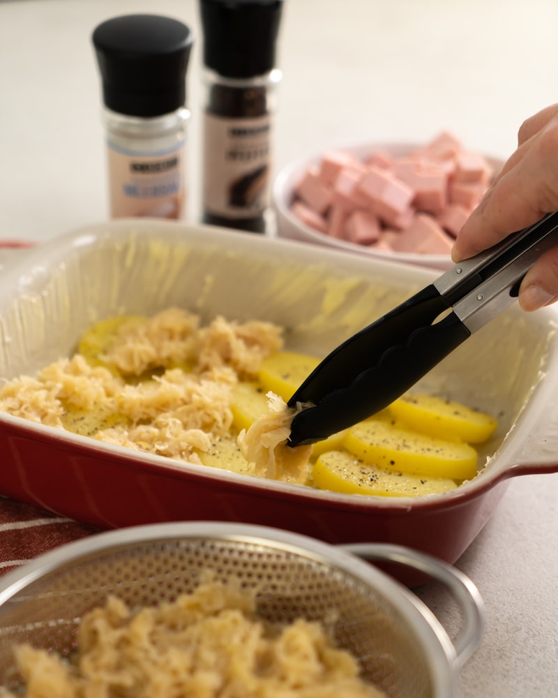 Auf diesem Bild siehst du wie das Sauerkraut in die Auflaufform gegeben wird.