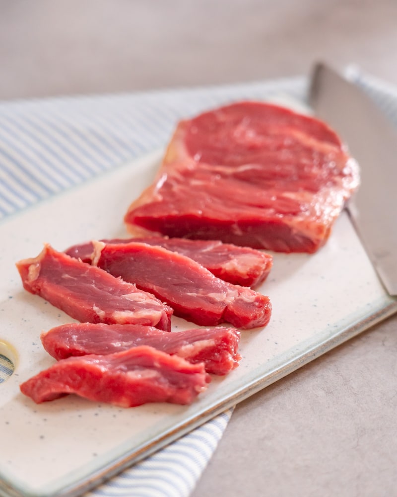 Dieses Bild zeigt wie das Fleisch in breite Streifen geschnitten ist.