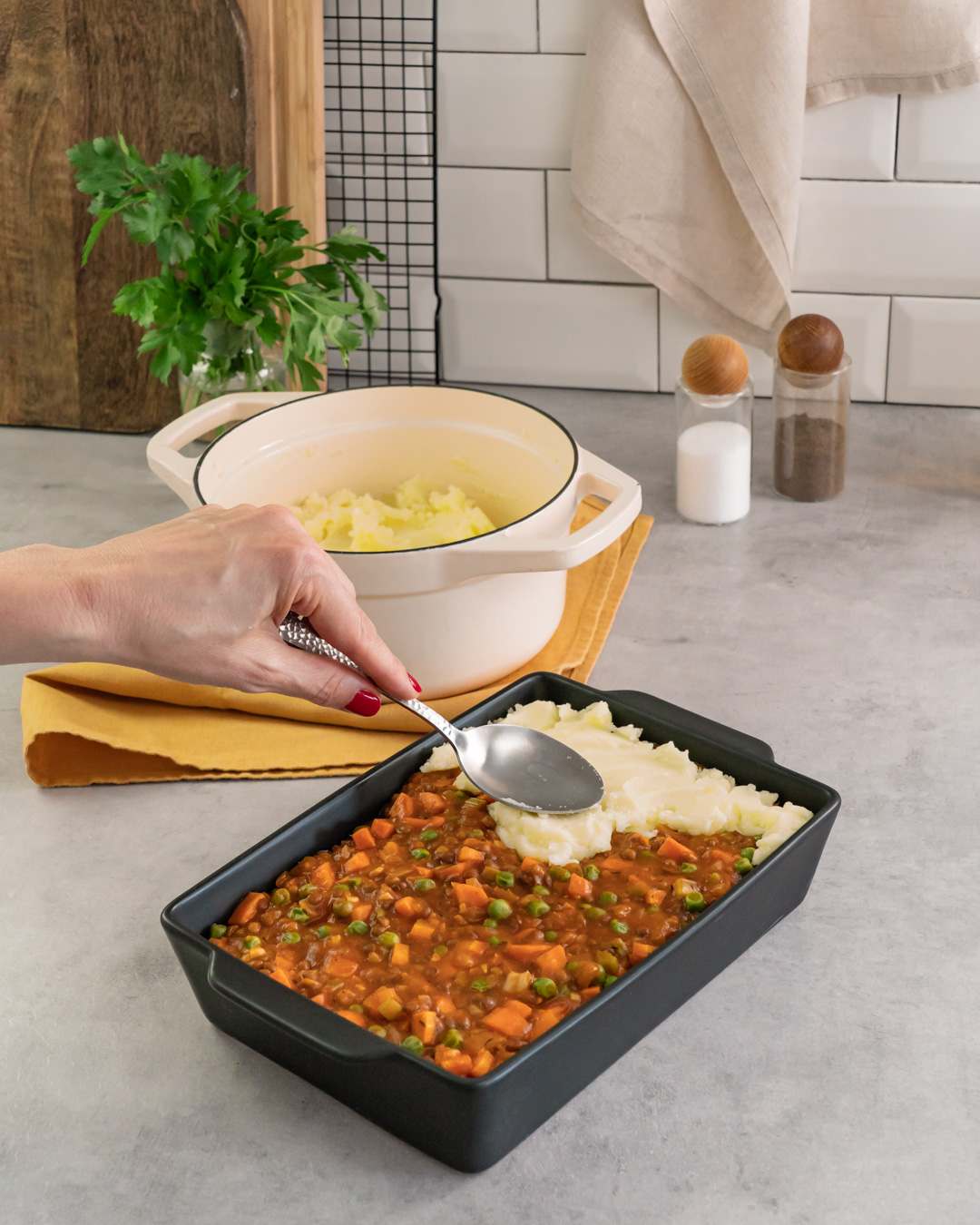Dieses Bild zeigt wie mit Kartoffelpüree abgedeckt wird.