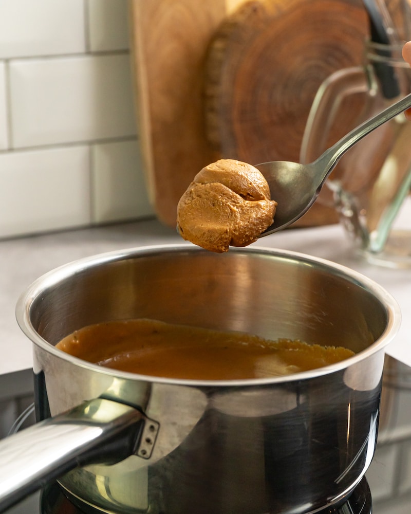 Dieses Bild zeigt wie die Erdnussbutter für die Sosse hinzugegeben wird.