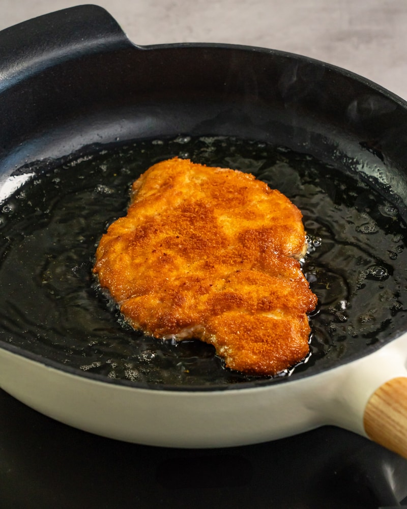 Dieses Bild zeigt wie das panierte Putenschnitzel im Butterschmalz gebraten wird.