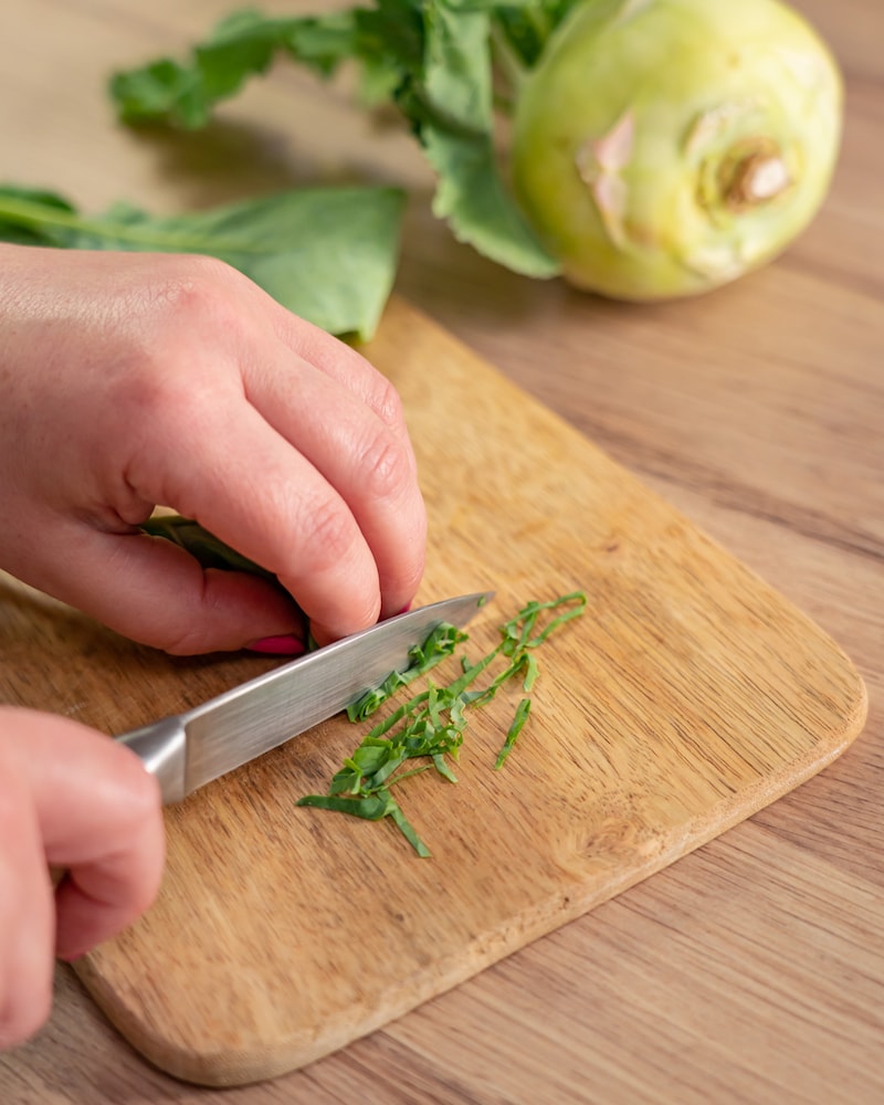 Dieses Bild zeigt, wie die Kohlrabiblätter geschnitten werden.
