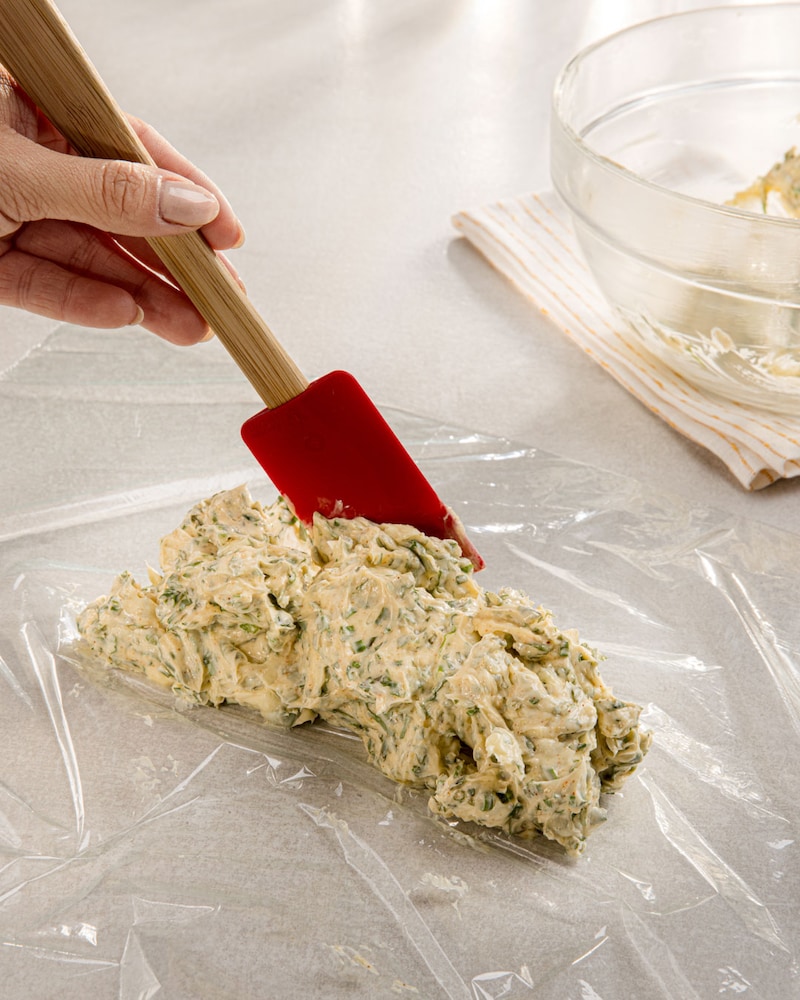 Dieses Bild zeigt wie die Zitronen-Kräuterbutter in  Frischhaltefolie gegeben wird.
