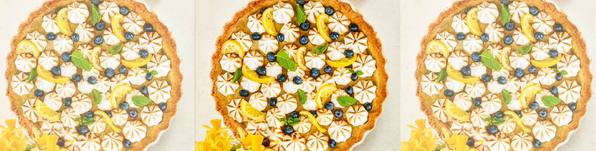 Dieses Bild zeigt die fertige Zitronentarte mit Baiser-Tuffs und Blaubeeren. 