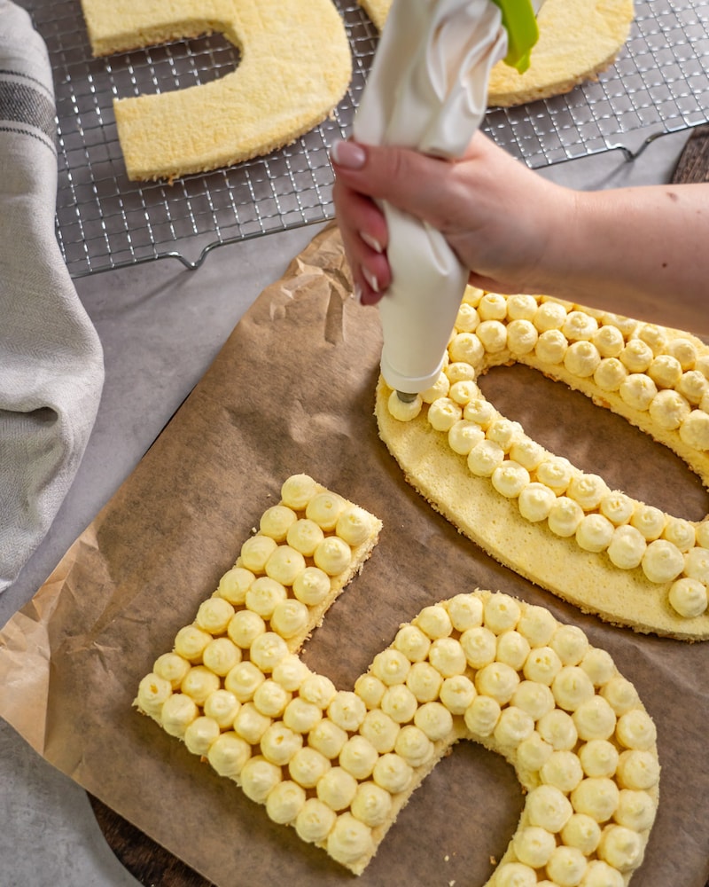 Dieses Bild zeigt wie die Creme auf den Kuchen gegeben wird.