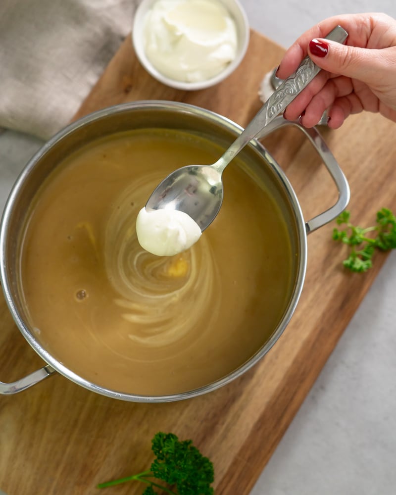 Dieses Bild zeigt wie die Suppe mit Crème fraîche verfeinert wird.