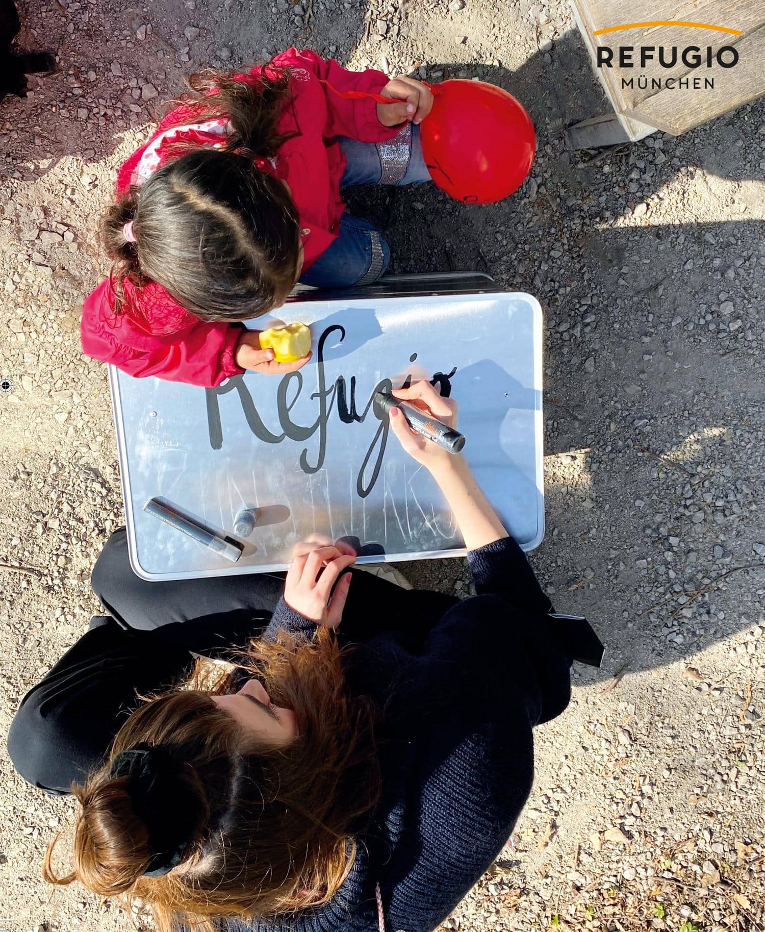 Kinder bemalen ein Schild mit dem Vereinslogo