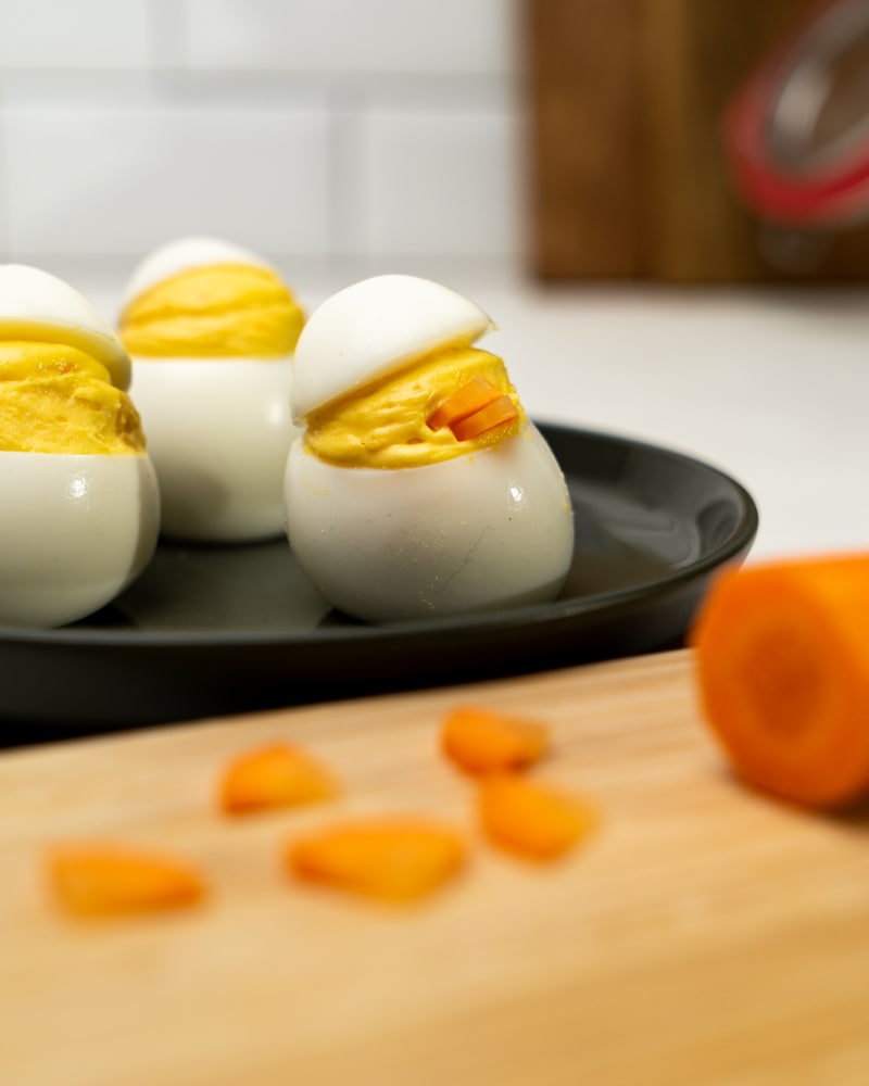 Auf diesem Bild siehst du wie zwei Möhrenstücke in die Creme gesteckt werden.
