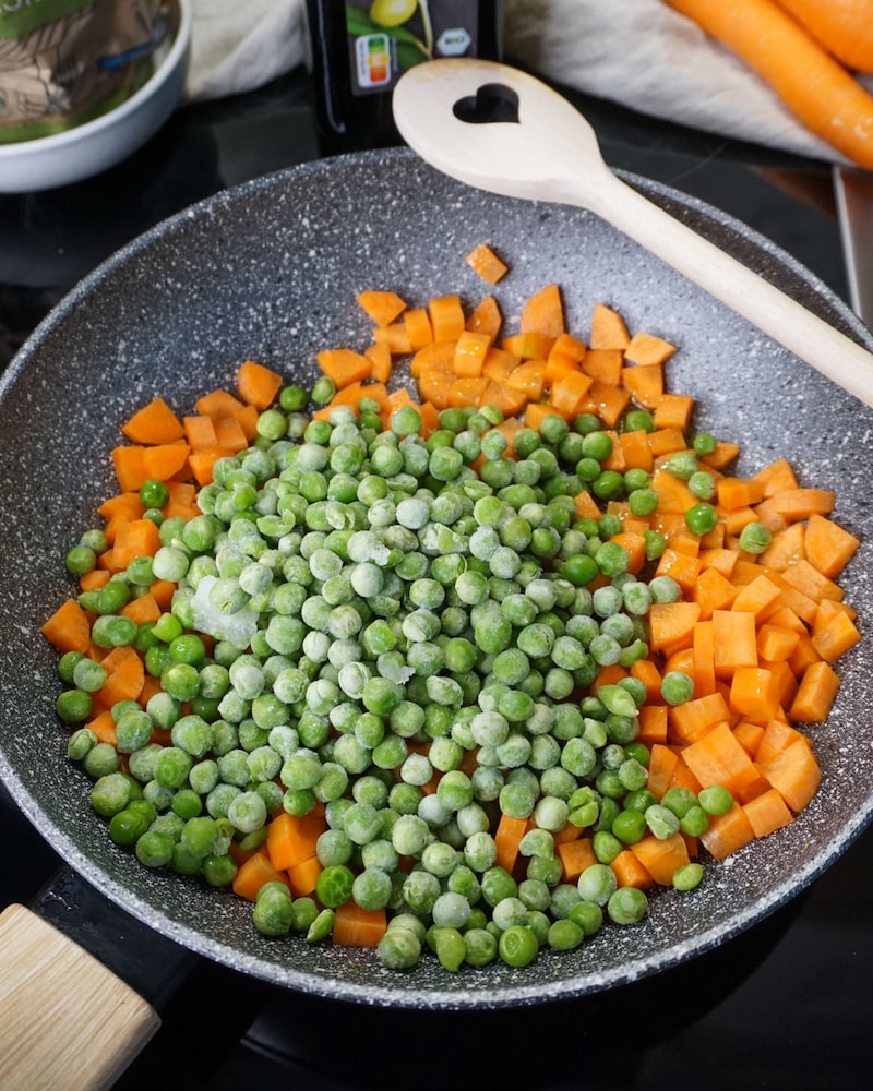 Dieses Bild zeigt die Erbsen und Möhren in der Pfanne.