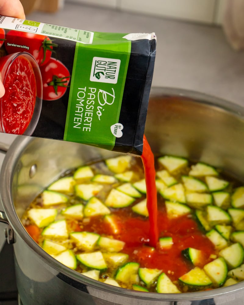 Dieses Bild zeigt wie die passierten Tomaten zur Brühe gegeben wird.