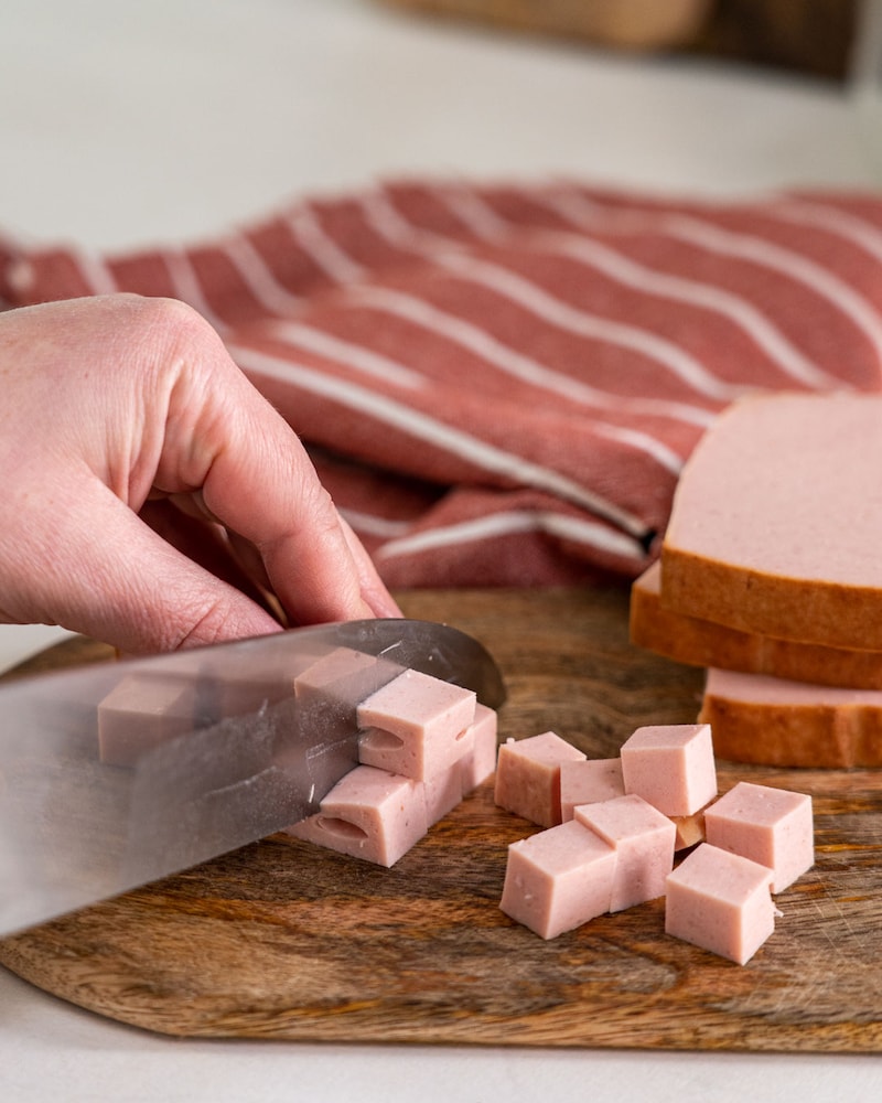 Auf diesem Bild siehst du wie Leberkäse geschnitten wird.