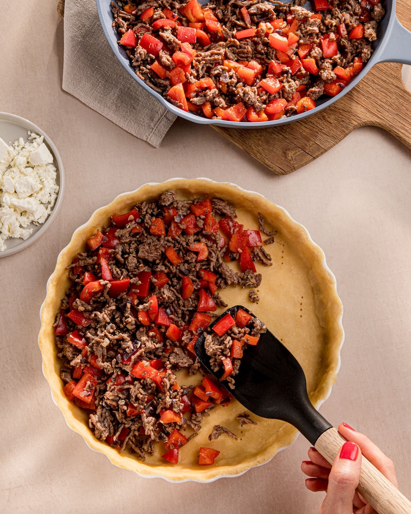 Dieses Bild zeigt wie die Quiche gefüllt wird.