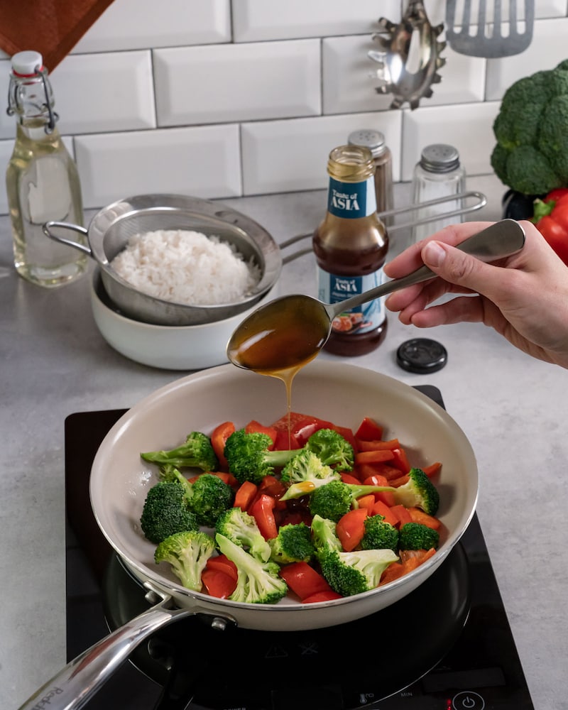 Dieses Bild zeigt wie das Gemüse in der Pfanne gewürzt wird.