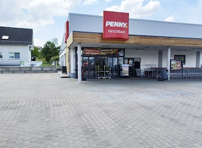 Sie sehen den Eingang vom Penny Markt in Herschbach Rheinstr. 24C
