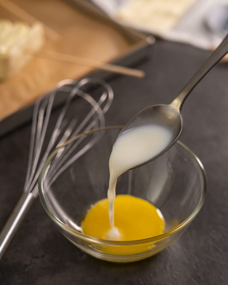 Dieses Bild zeigt wie Eigelb mit Milch vermengt wird.