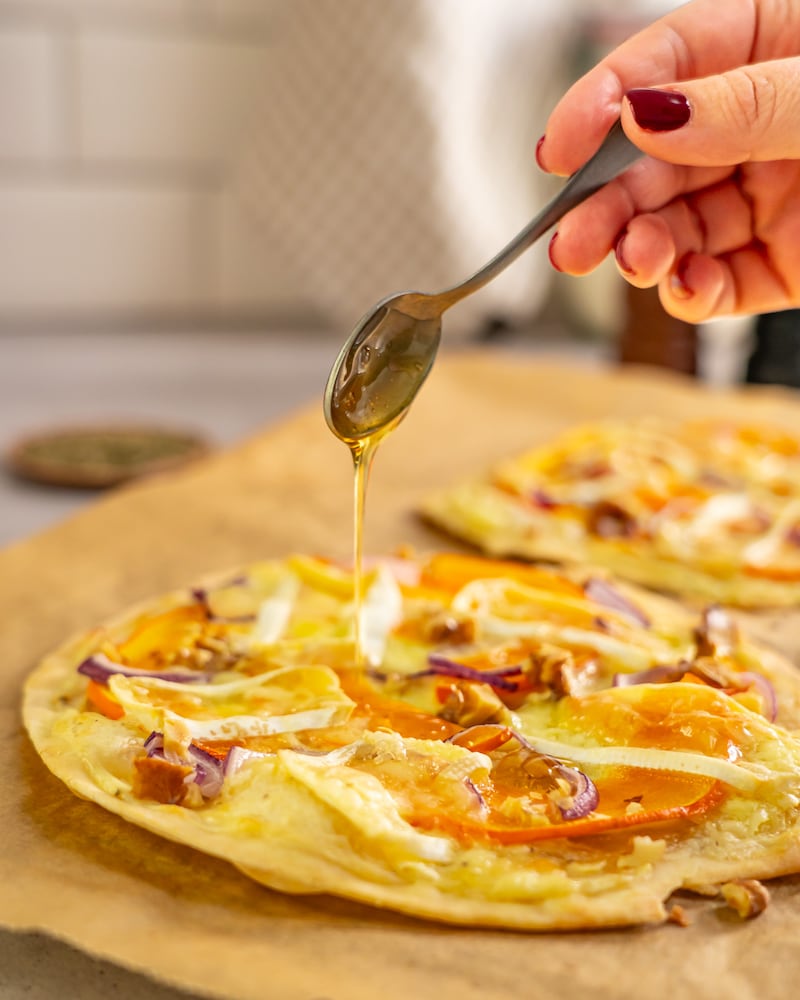Dieses Bild zeigt wie der Honig auf den Flammkuchen gegeben wird.