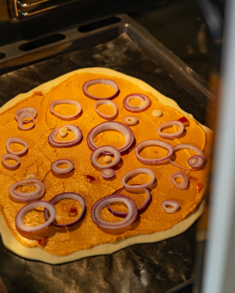 Dieses Bild zeigt wie der Flammkuchen in den Ofen geschoben wird.