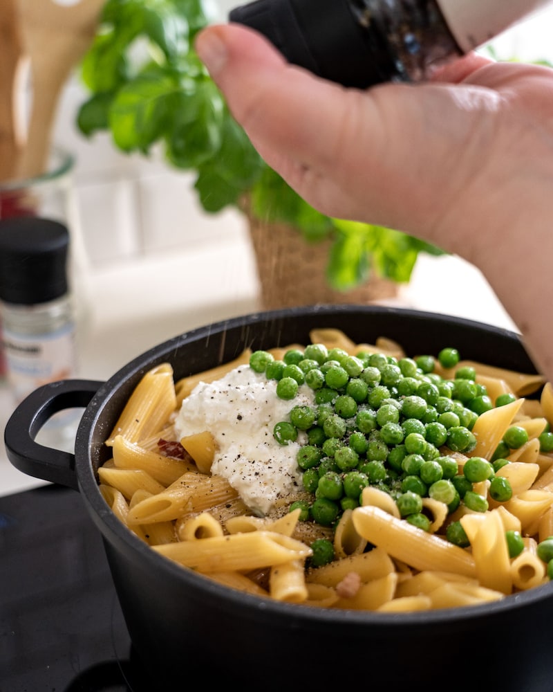 Dieses Bild zeigt wie die Pasta gewürzt wird.