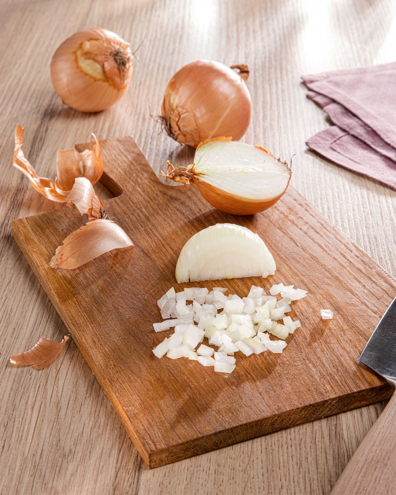 Dieses Bild zeigt eine zur Hälfte gewürfelte Zwiebel.
