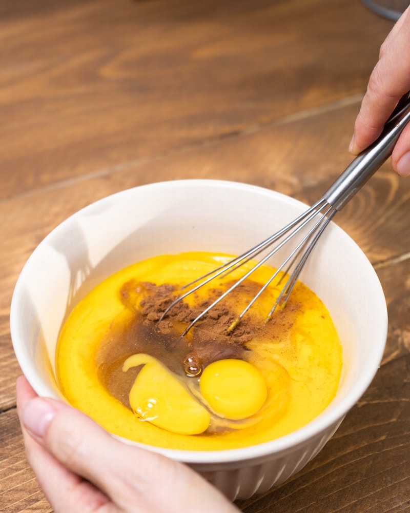 Auf diesem Bild siehst du wie die Kürbiscreme mit Eigelb und Kakaopulver verrührt wird.