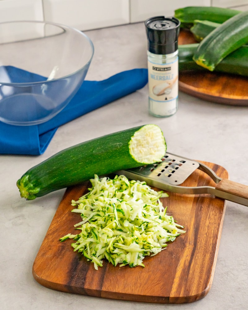 Dieses Bild zeigt wie die Zucchini geraspelt wird.