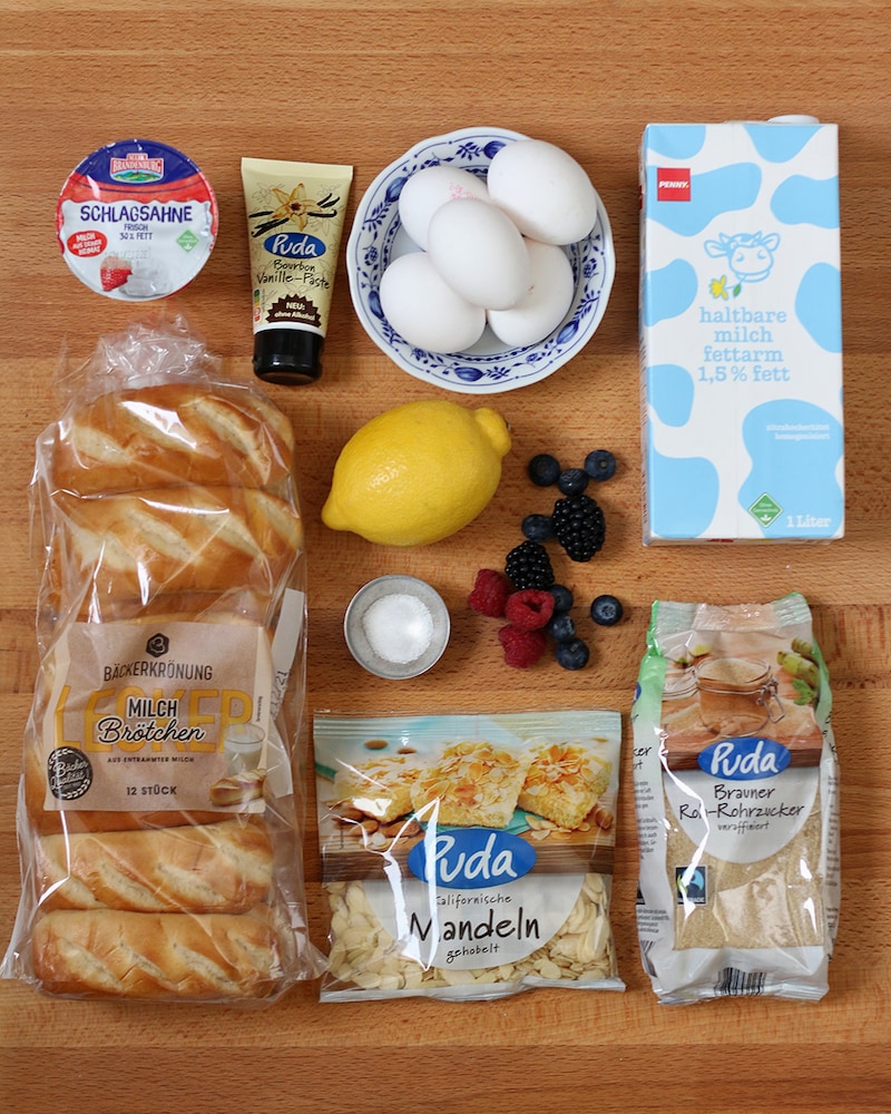 Auf diesem Bild siehst du alle Zutaten für unseren Ofenschlupfer mit Beeren und Mandeln.