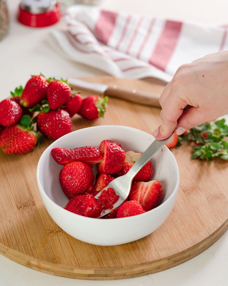 Das Bild zeigt wie Erdbeeren zerdrückt werden.