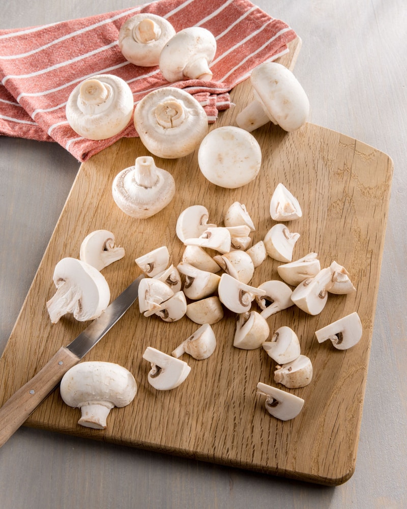 Dieses Bild zeigt, wie die Champignons geschnitten werden.