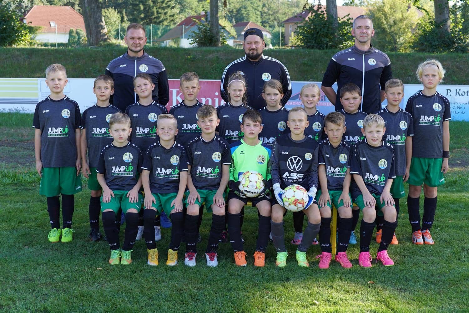 Eine Jungen-Fußballmannschaft laechelt in die Kamera