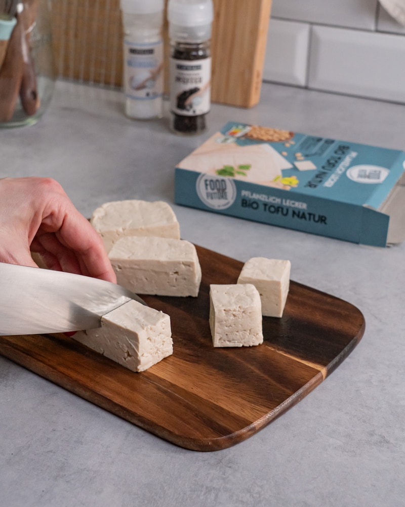Dieses Bild zeigt, wie der Tofu geschnitten wird.