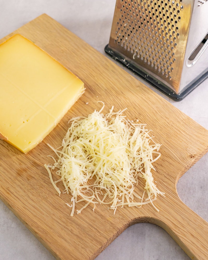 Dieses Bild zeigt wie der Käse gerieben wird.