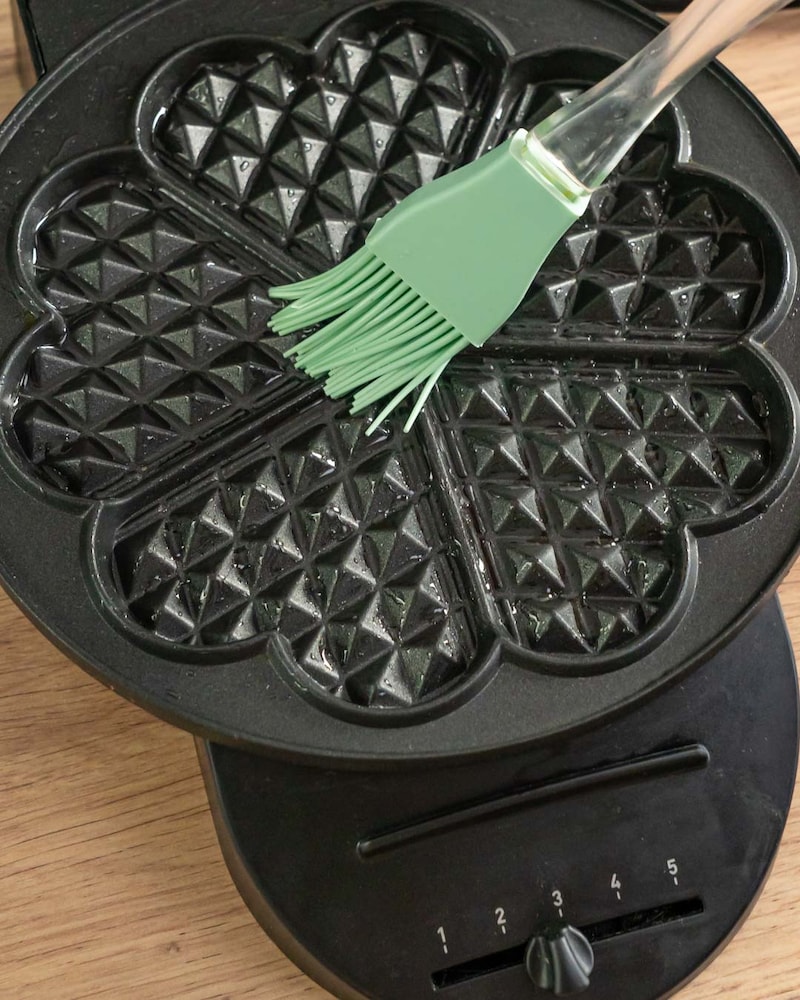 Dieses Bild zeigt wie das Waffeleisen eingefettet wird.