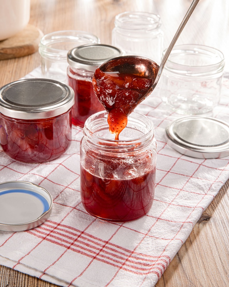 Dieses Bild zeigt wie die Erdbeermarmelade in die Gläser gefüllt wird.