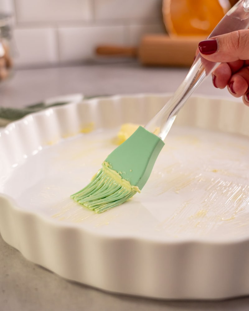 Dieses Bild zeigt wie die Kuchenform mit Butter eingefettet wird.