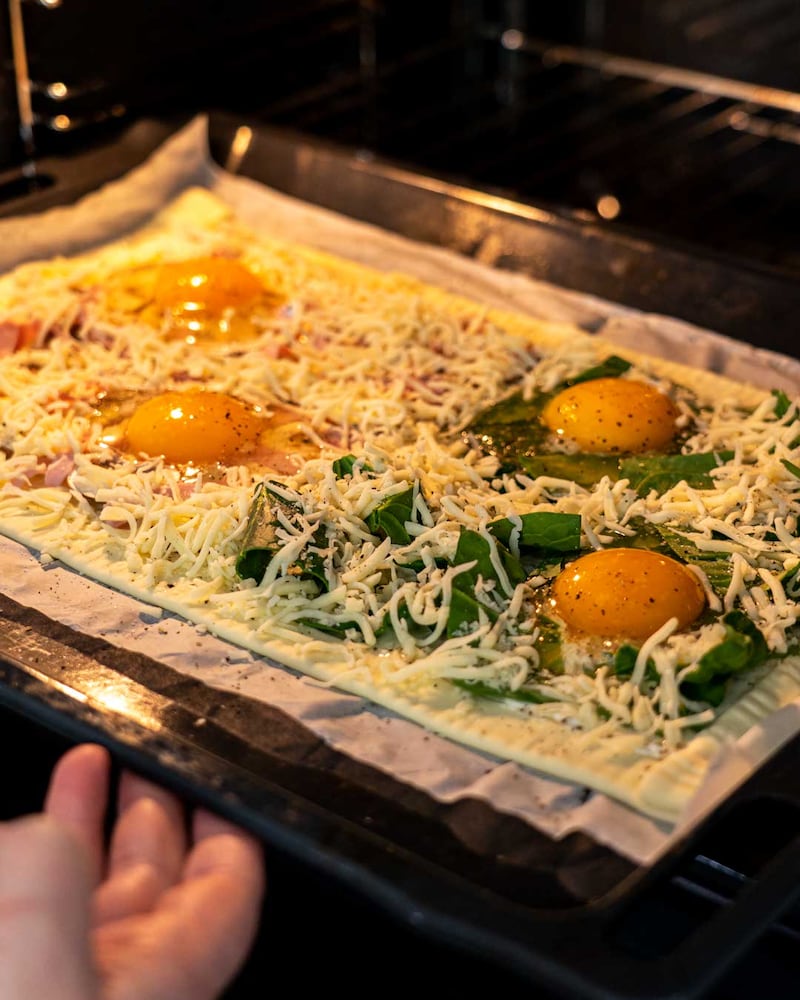 Auf diesem Bild siehst du wie die Pizza in den Ofen gegeben wird.