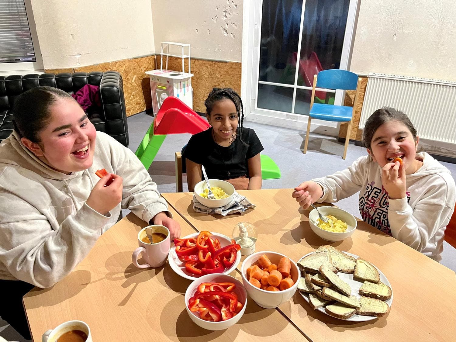 Kinder sitzen am Tisch und fruehstuecken