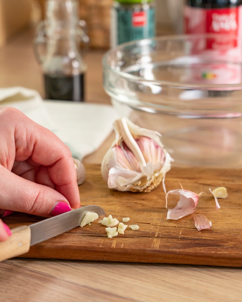 Dieses Bild zeigt, wie Knoblauch gehackt wird.